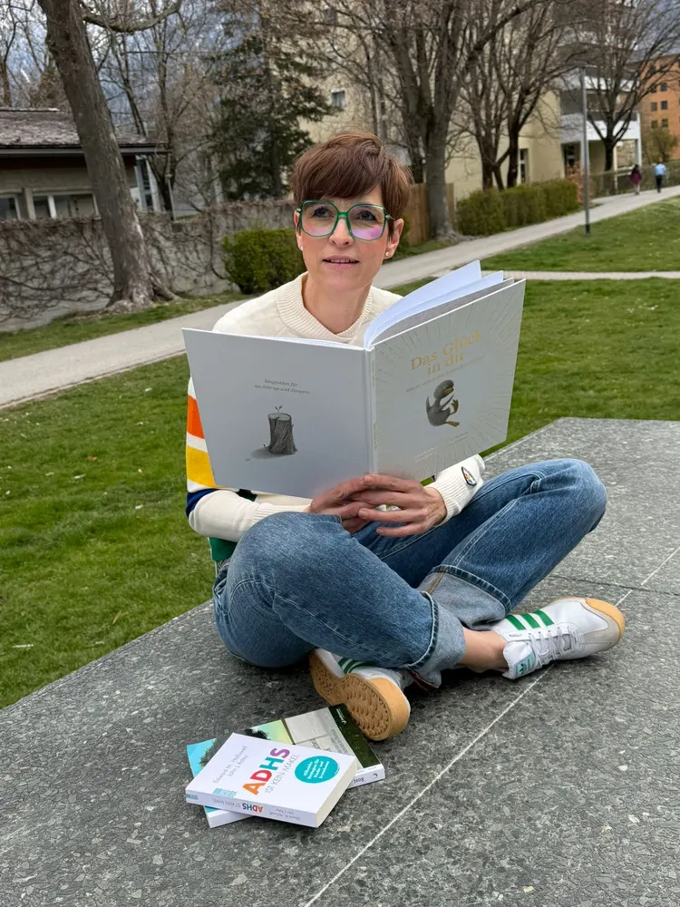 Katja liest ein Buch im Park