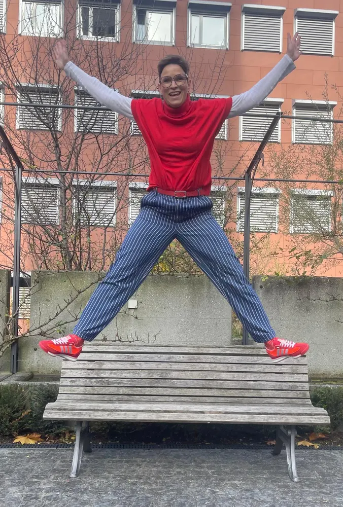 Katja springt fröhlich auf einer Bank